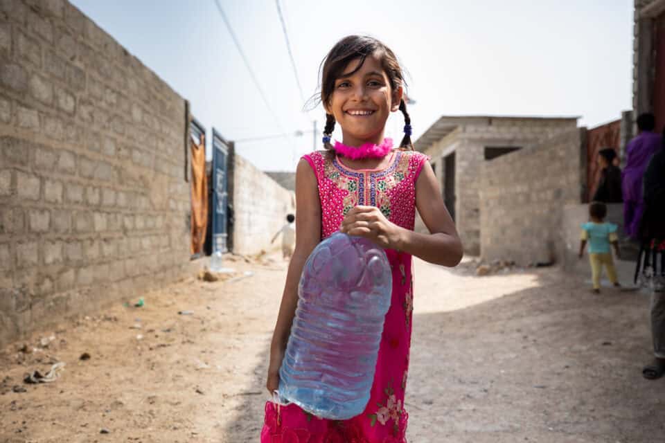 People get safe drinking water from a filtration facility in Karachi, Pakistan. The facilities were installed through a decades-long partnership between Rotary clubs and Coca Cola Pakistan. Rotary members also worked with the community to provide hygiene training and to teach community members how to operate and maintain the equipment to ensure sustainability. 25 October 2021.