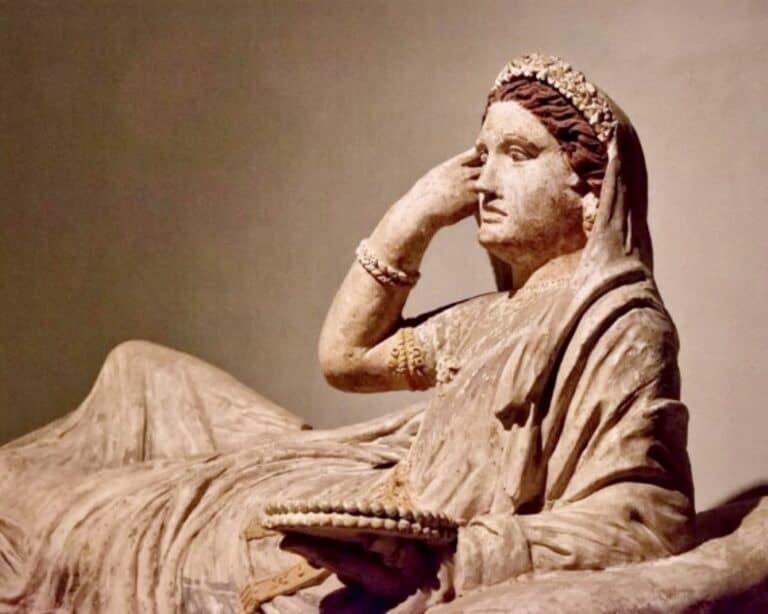 An Etruscan terracotta sarcophagus lid depicting one Larthia Seianti. 2nd century BCE. The woman has her right hand up to her face and is lying recumbant looking to her left.