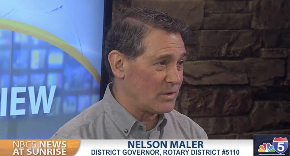 DG Nelson Maler on Service, Success, and Celebration 2 Nelson Maler sits in a news studio for an interview. He is in front of a large projection screen and is wearing a button-up polo shirt with Rotary District 5110 embroidered above the pocket.