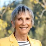 Christine Waugh headshot wearing yellow jacket
