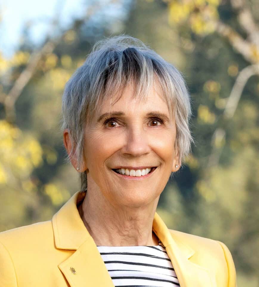Christine Waugh headshot wearing yellow jacket