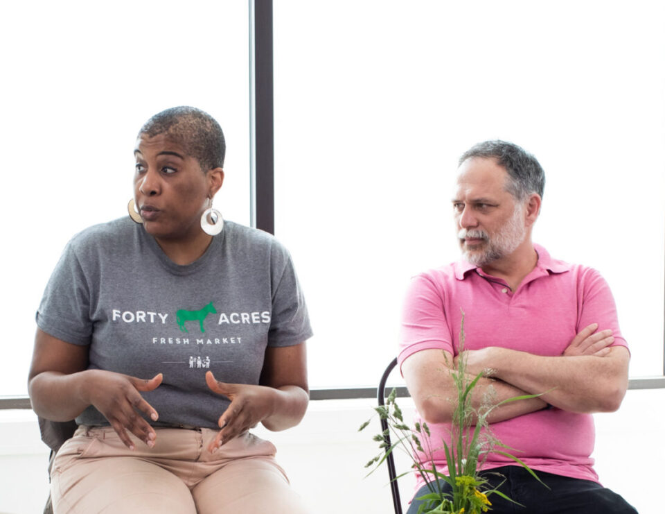 A woman and a man are seated on a panel discussion in a conference room. They are talking about food insecurity in Chicago.